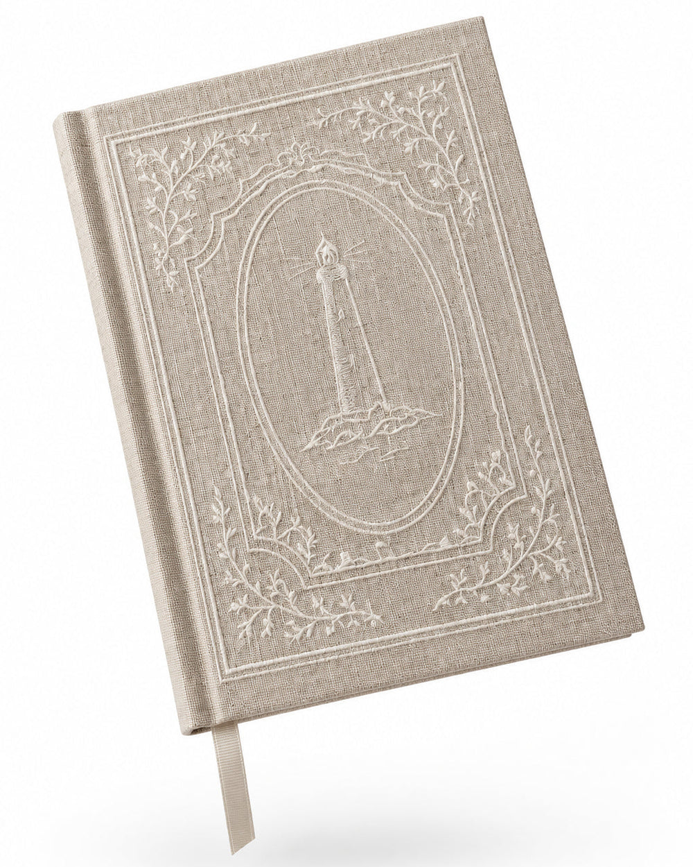 A hand holding a hardcover journal with a beige linen cover and white embossed decorative border and lighthouse design, against a solid gray background.